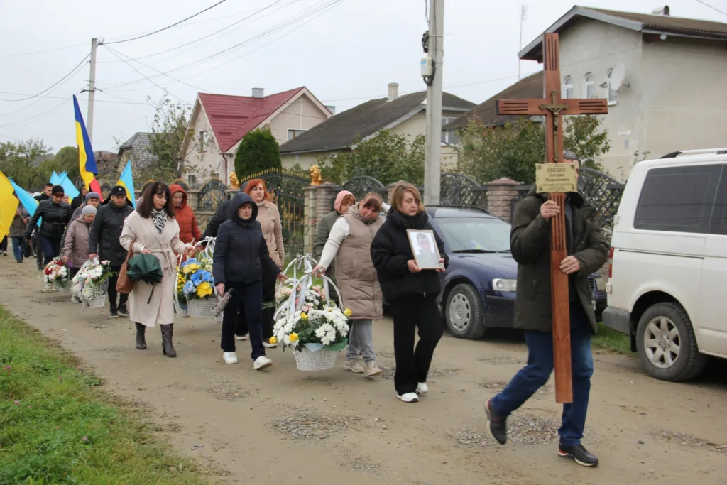 Похоронна процесія з квітами та прапорами України