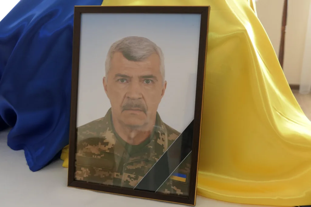 Портрет українського військового на тлі прапора