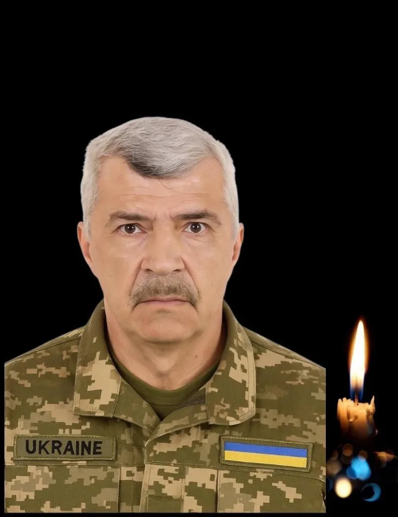 Український військовий у формі поруч із свічкою пам'яті