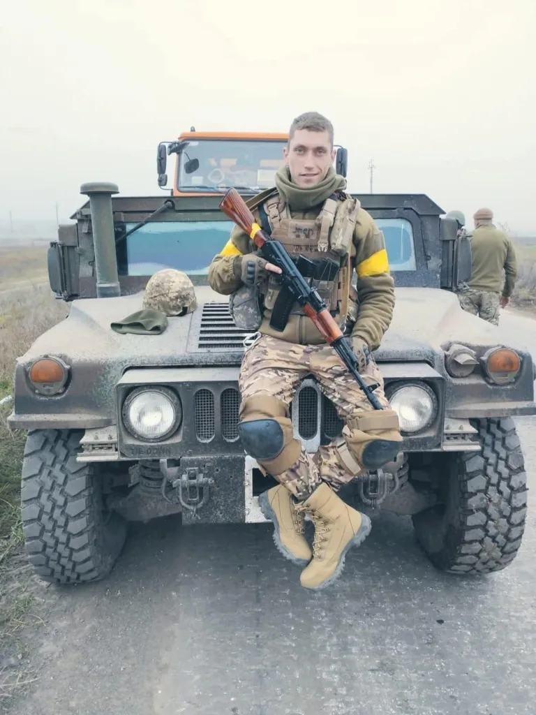 Український солдат сидить на військовому джипі
