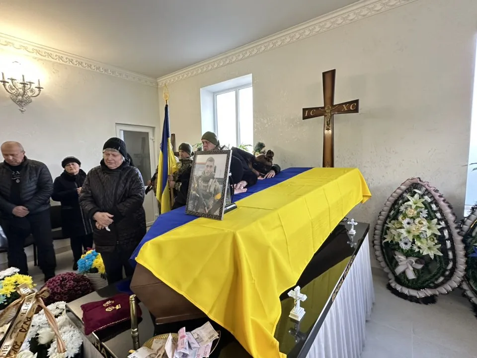 Похорон військового з труною, накритою прапором України
