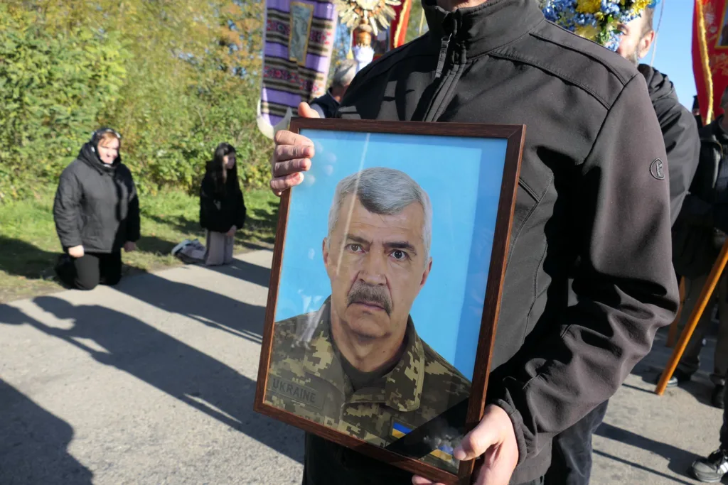 Людина тримає портрет українського військовослужбовця