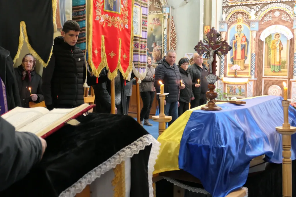 Похоронна церемонія в українській церкві з прапором