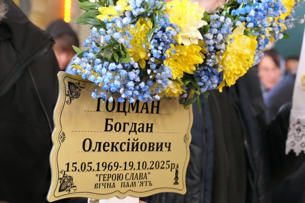 Квіти та табличка на похоронній церемонії