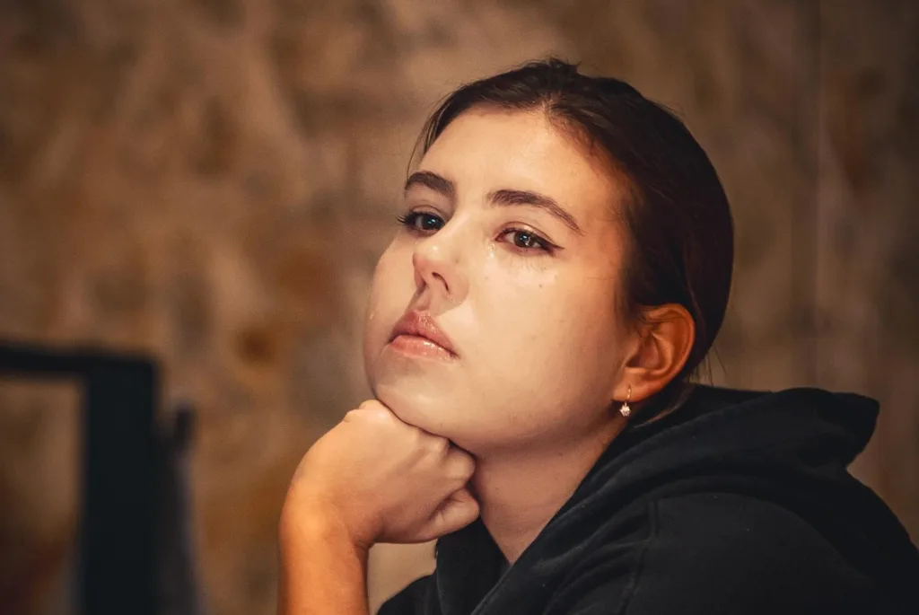 Замислена дівчина спирається на руку