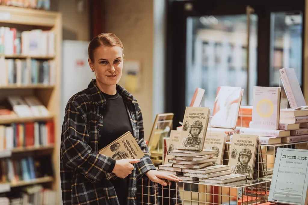 Жінка в книгарні тримає книгу про війну