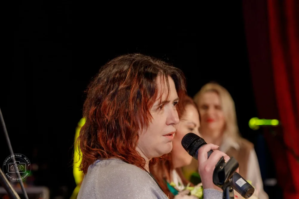 Жінка виступає з мікрофоном на сцені