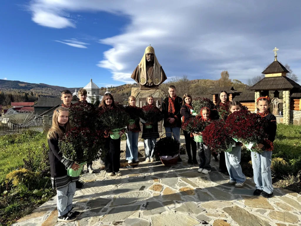 Діти з квітами біля пам’ятника у горах