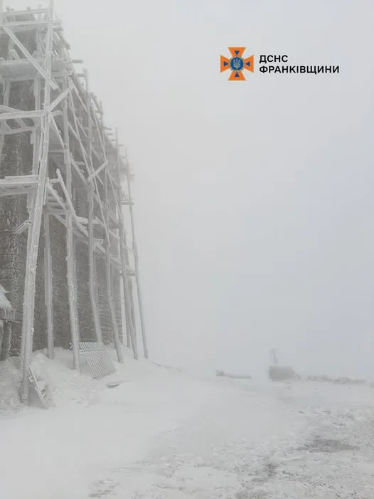 Засніжена будівля в горах у тумані