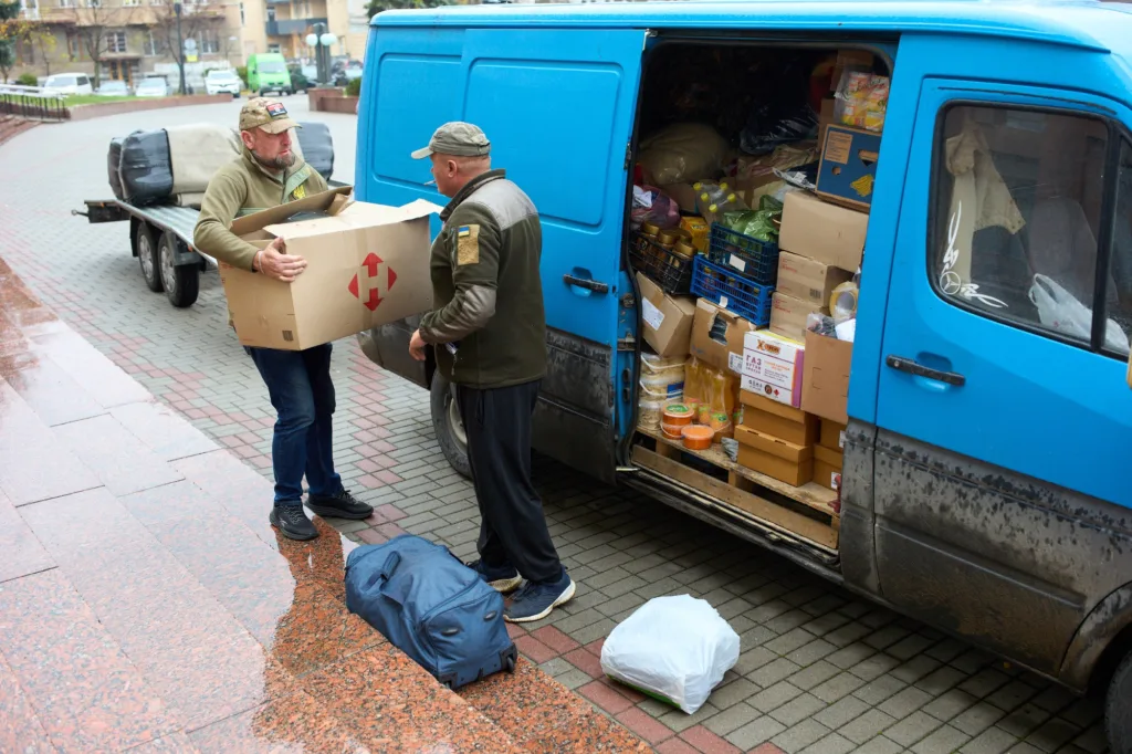 Волонтери розвантажують гуманітарну допомогу з фургона