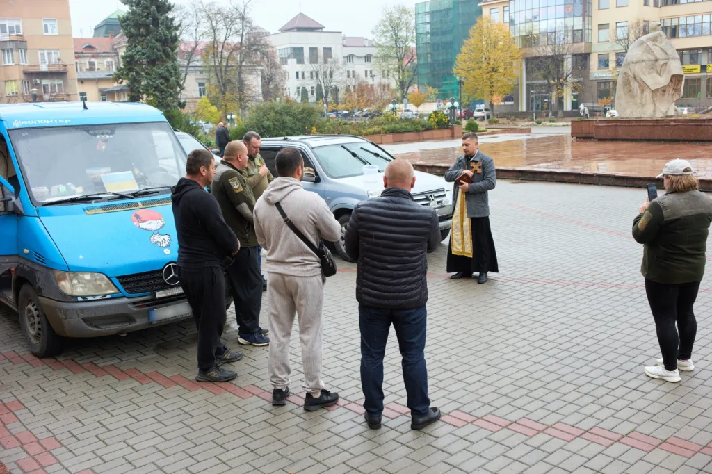 Священник благословляє волонтерів перед поїздкою
