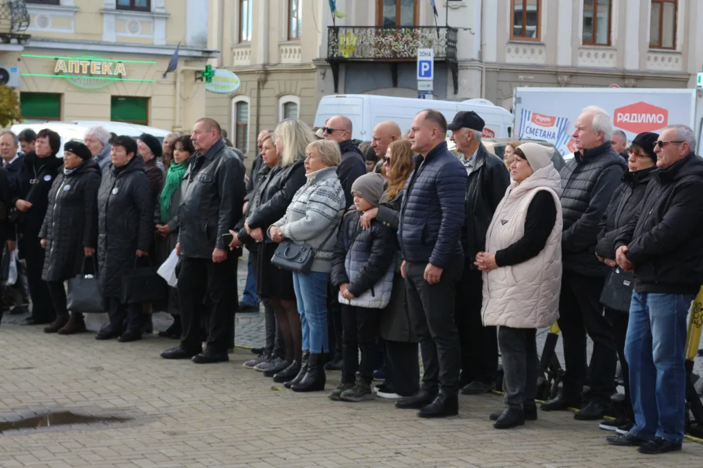 Люди стоять на вуличному заході в місті