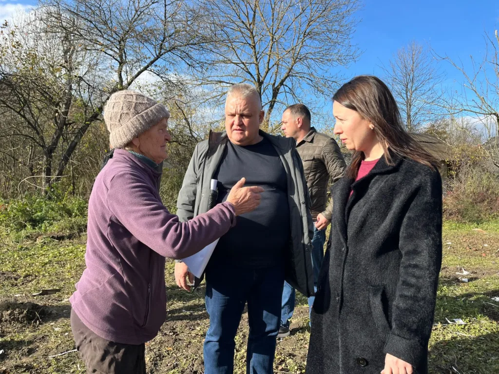 Люди розмовляють на вулиці серед дерев восени