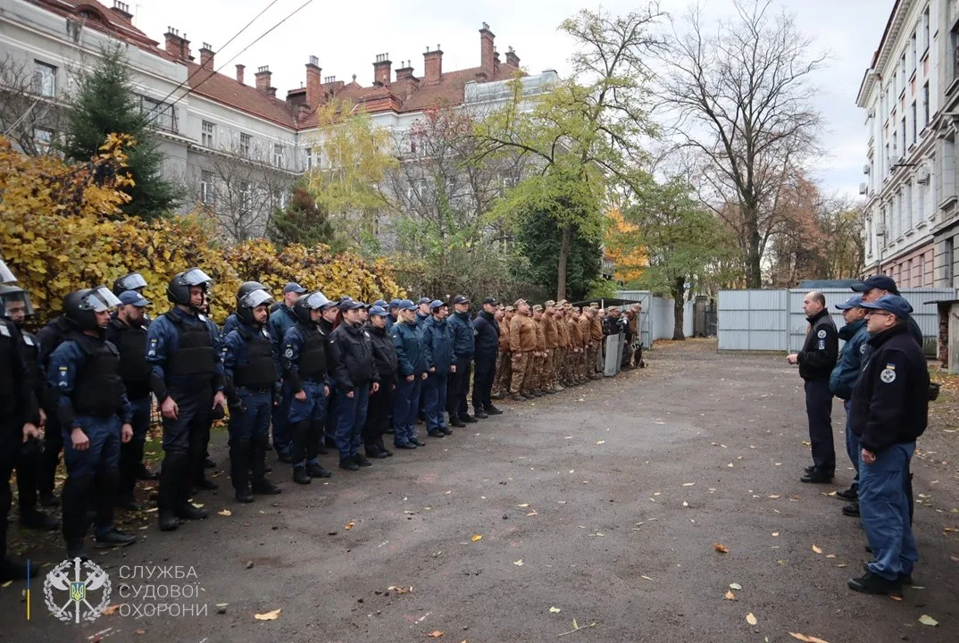 Поліцейські та військові на шикуванні у дворі будівлі