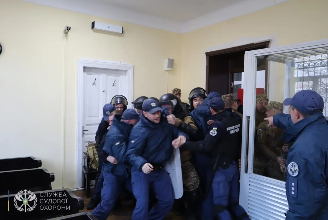 Охоронці затримують чоловіків у будівлі суду