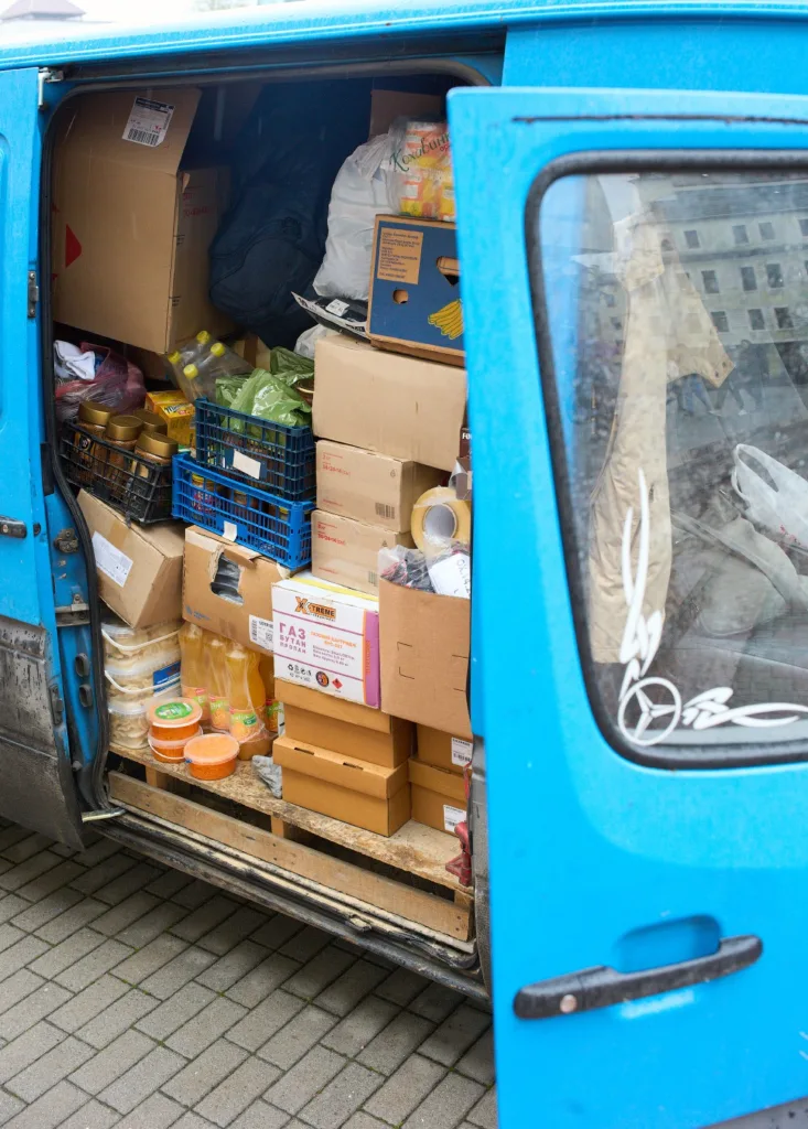 Синій фургон, заповнений коробками з продуктами
