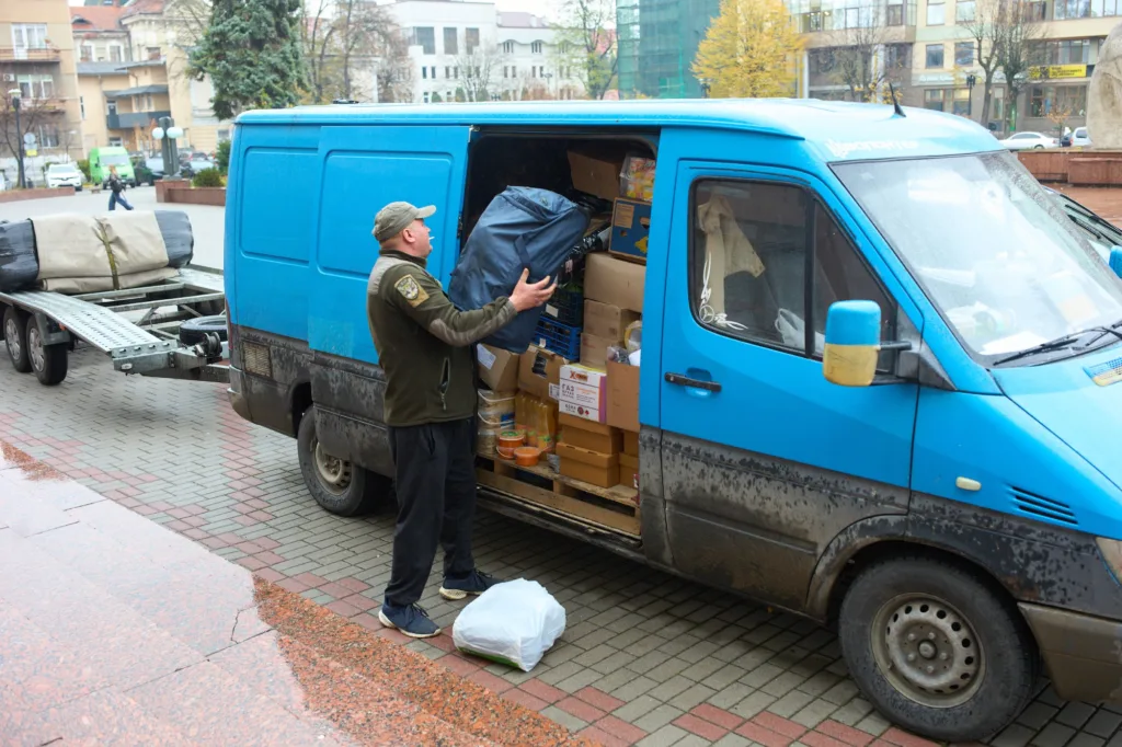 Чоловік завантажує речі у синій фургон