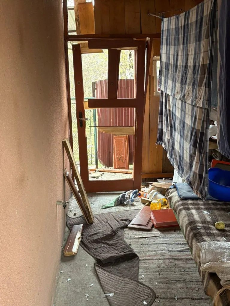 Пошкоджена кімната з розбитими дверима та безладом