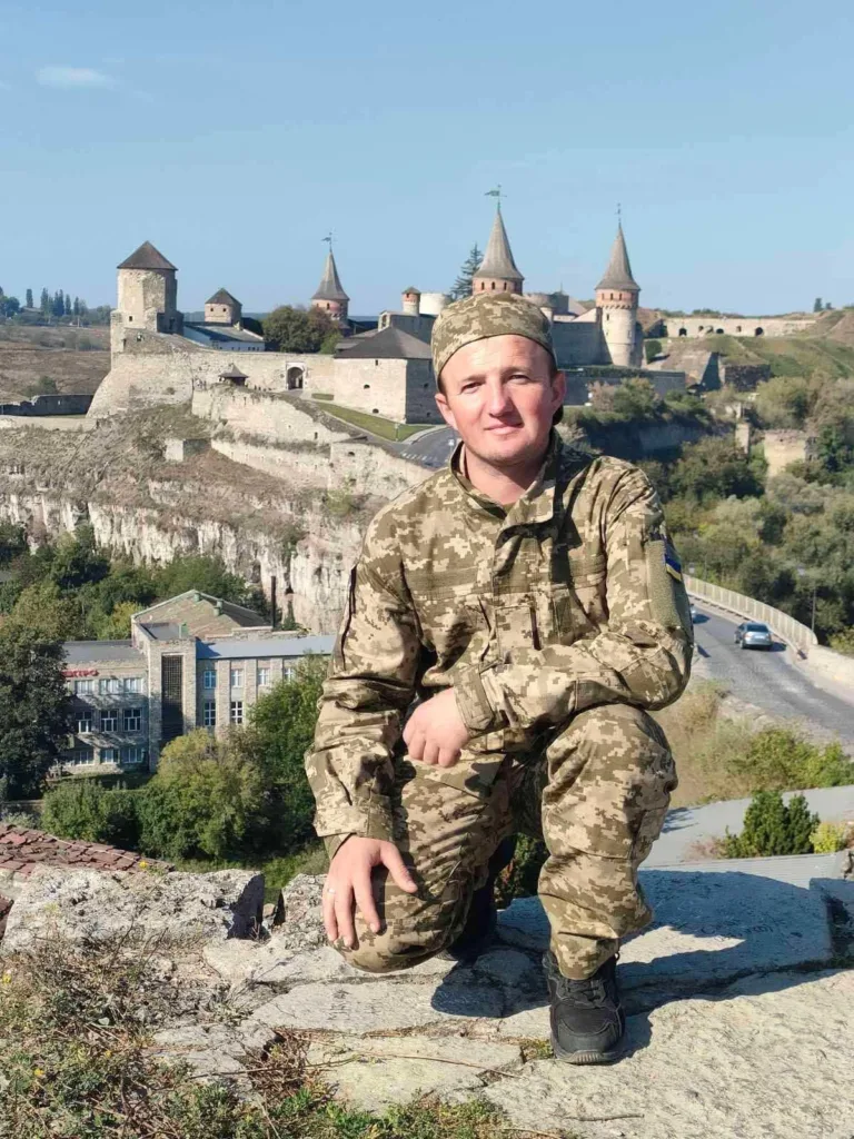 Військовий на фоні старовинного замку в Україні