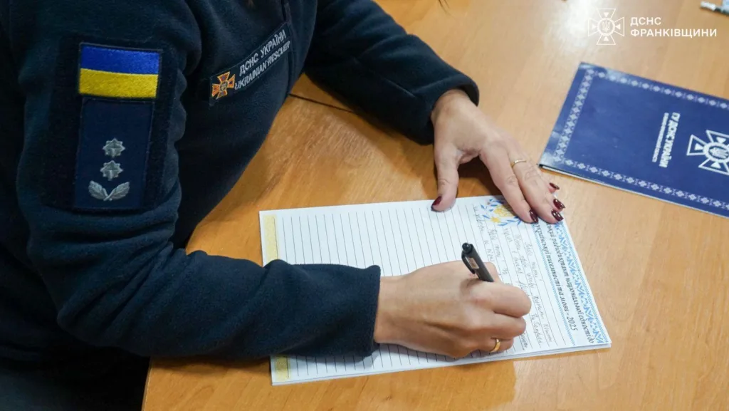 Рятувальниця ДСНС заповнює офіційний документ на столі
