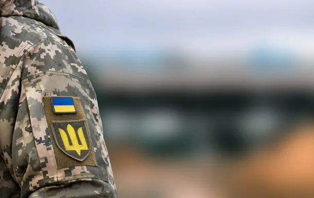 Український військовий у камуфляжі з прапором України