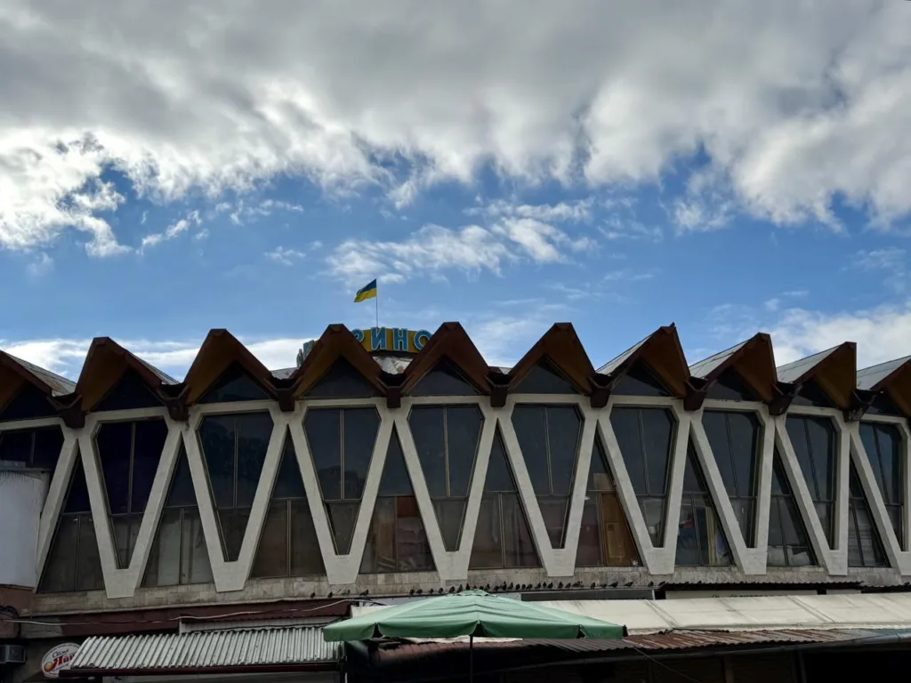 Будівля з українським прапором під хмарним небом