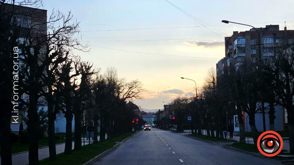 Вечірнє місто з вулицею та ліхтарями
