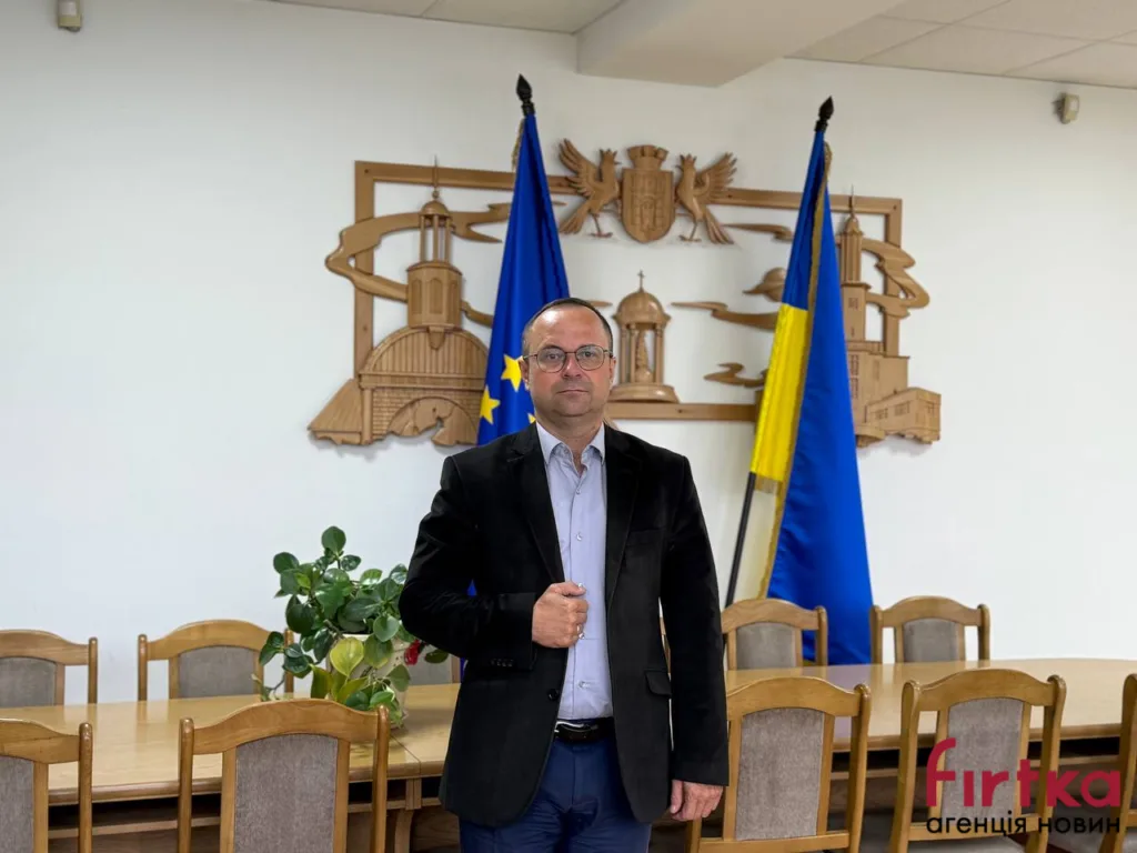 Чоловік у залі з прапорами України та ЄС