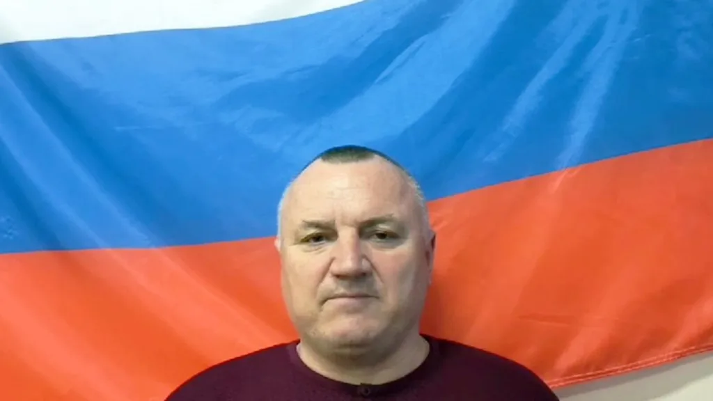 Чоловік стоїть перед російським прапором