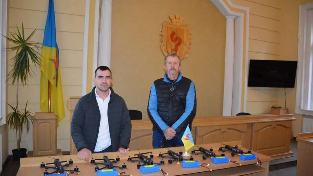 Двоє чоловіків у залі з дронами на столі