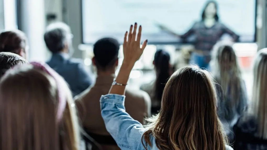 Студент піднімає руку на лекції