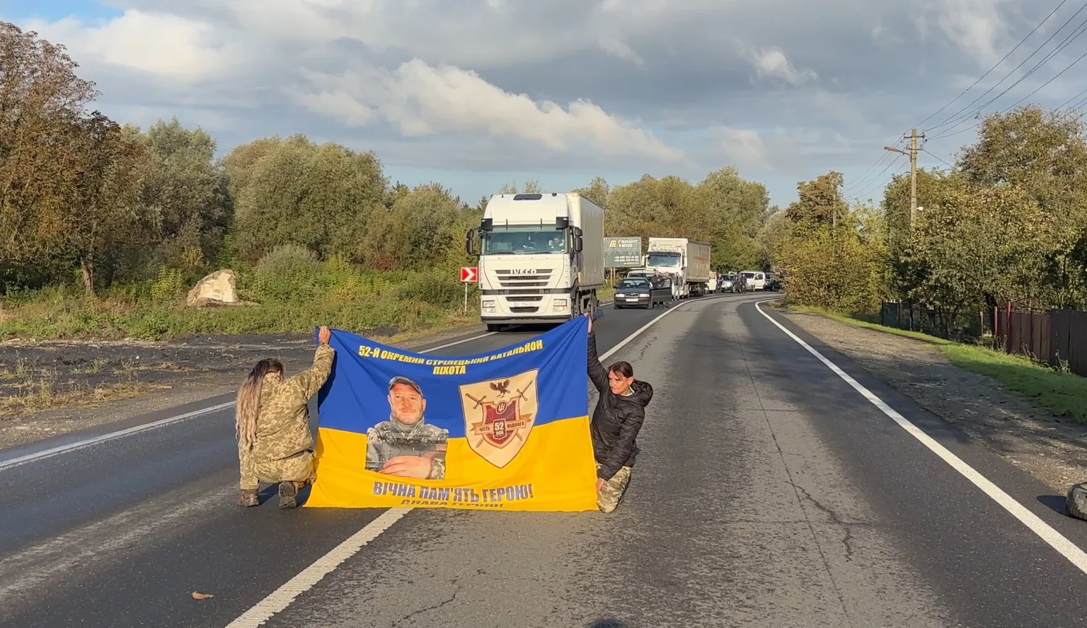 Військові тримають прапор батальйону на дорозі