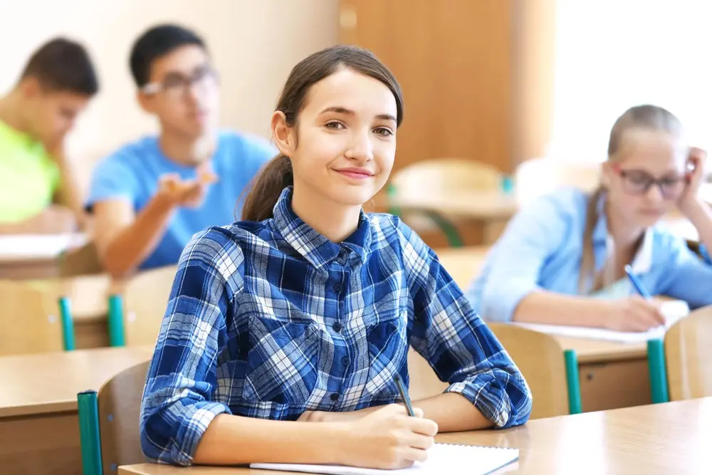 Учениця пише у класі під час уроку