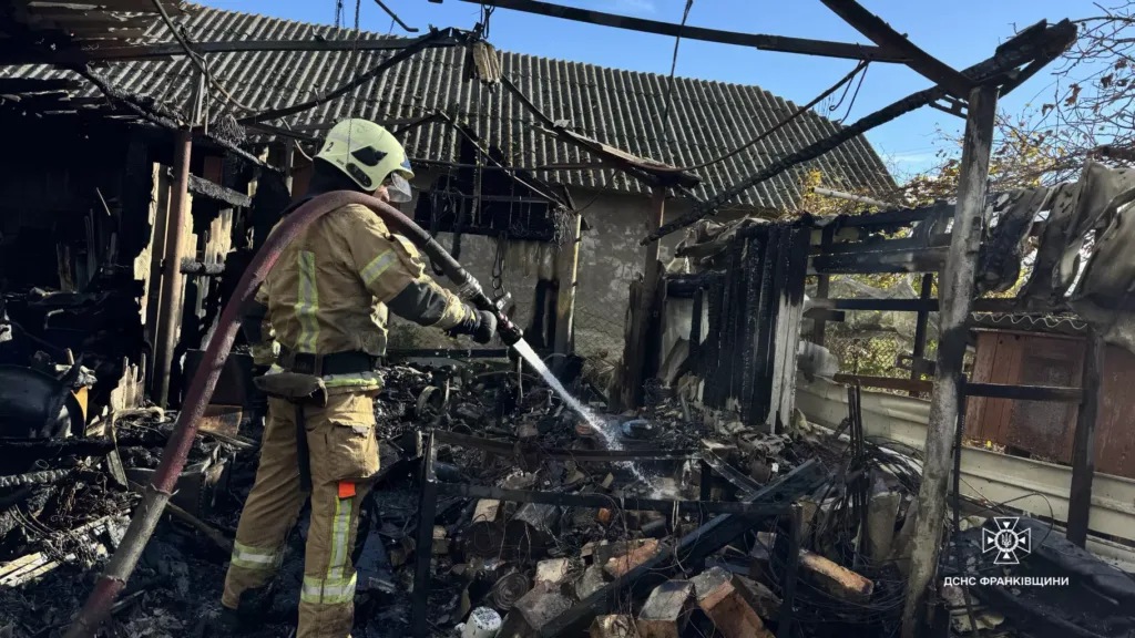 Рятувальник гасить пожежу в зруйнованій будівлі