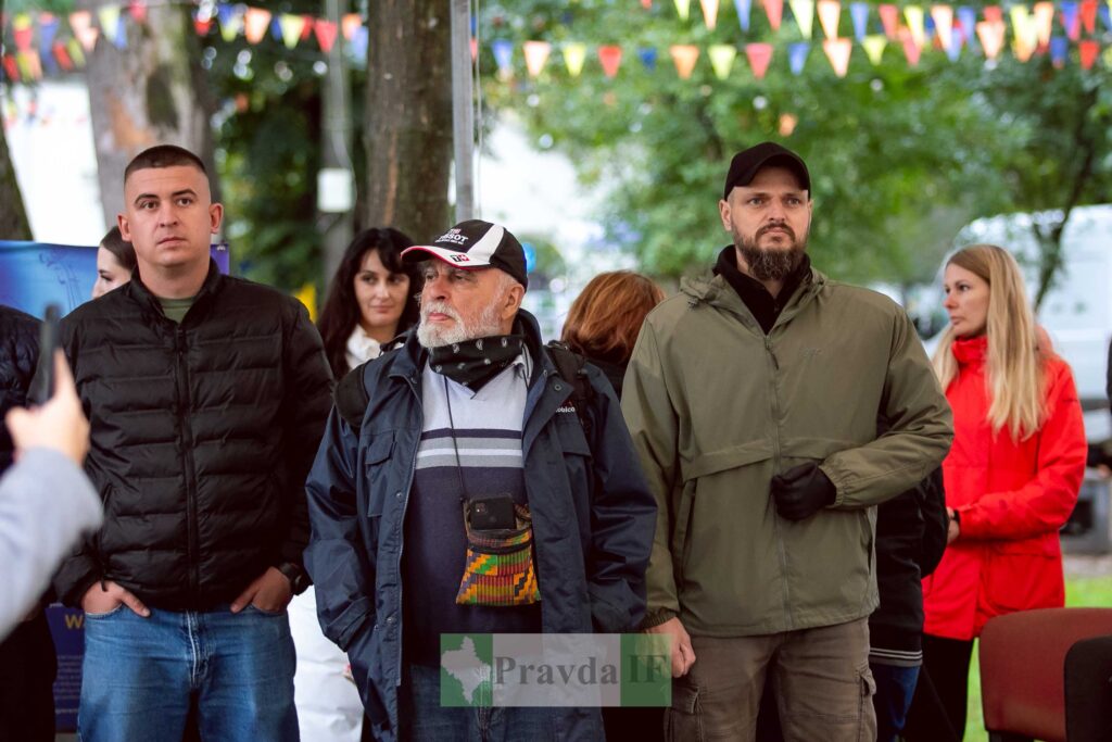 Група людей на вулиці, святкове оформлення.