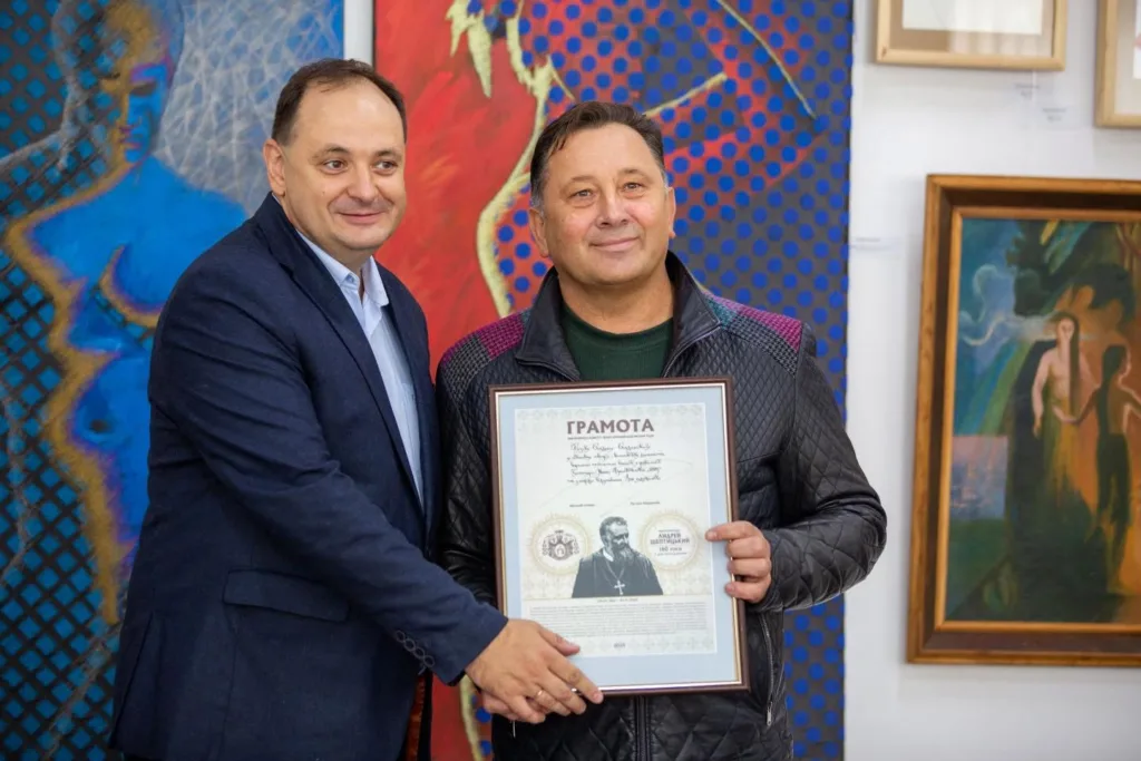 Двоє чоловіків тримають почесну грамоту на виставці