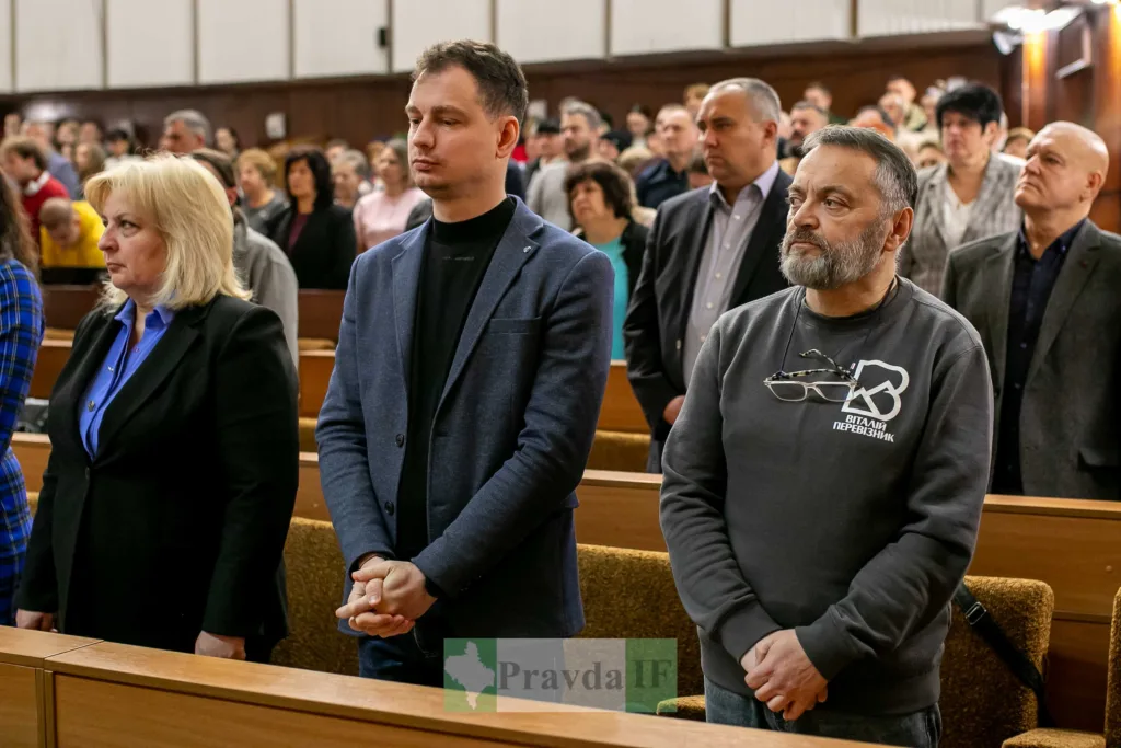 Люди стоять у залі під час зборів