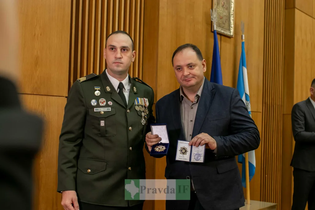 Військовий вручає нагороду чоловікові у костюмі