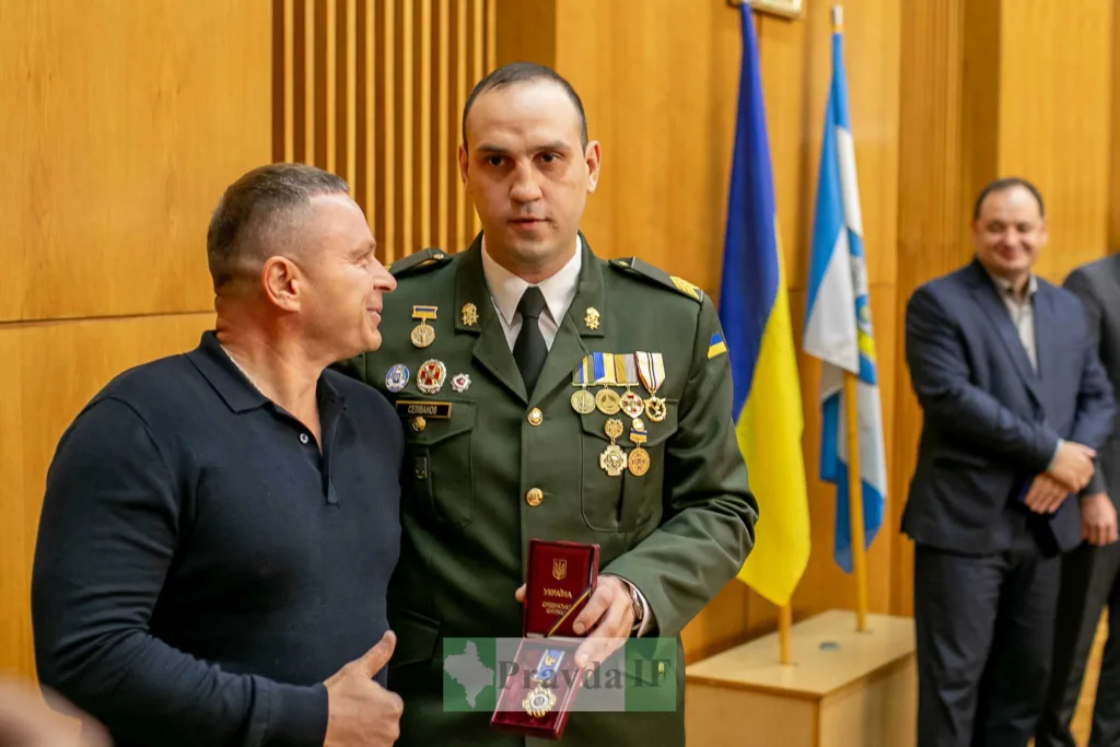 Військовий отримує нагороду в урочистій залі