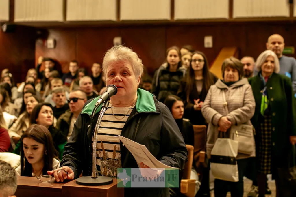 Жінка виступає на громадських слуханнях у залі