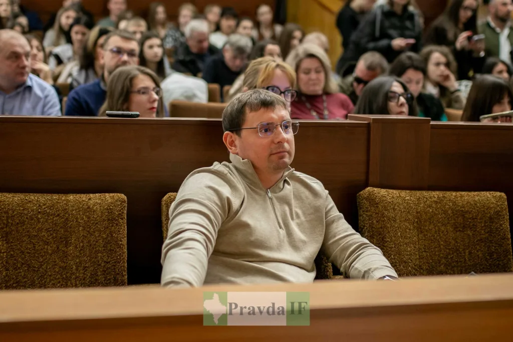 Чоловік на конференції у залі з людьми