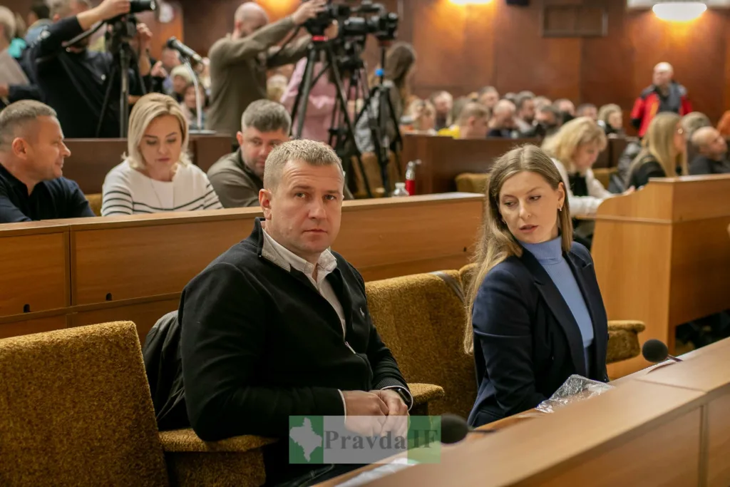 Люди на засіданні в залі з мікрофонами