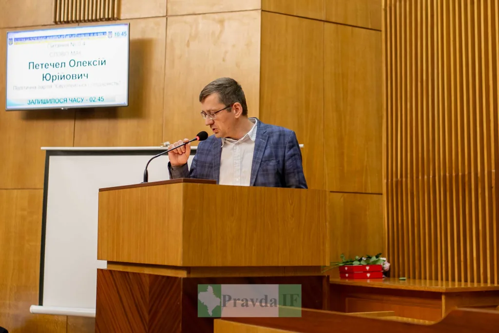 Чоловік виступає на трибуні у залі засідань