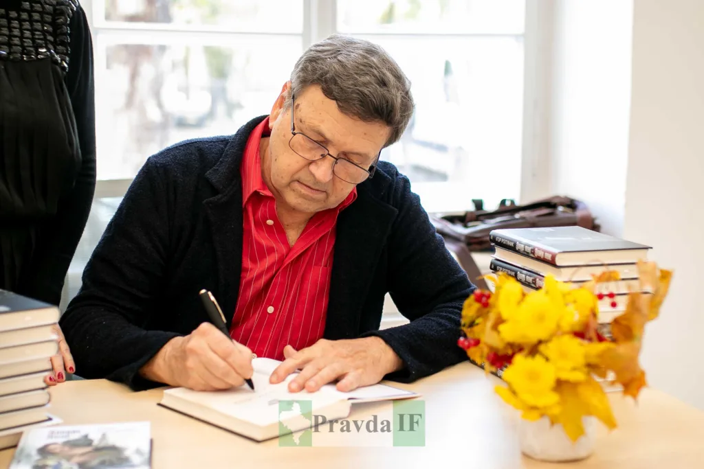 Чоловік підписує книгу на зустрічі з читачами