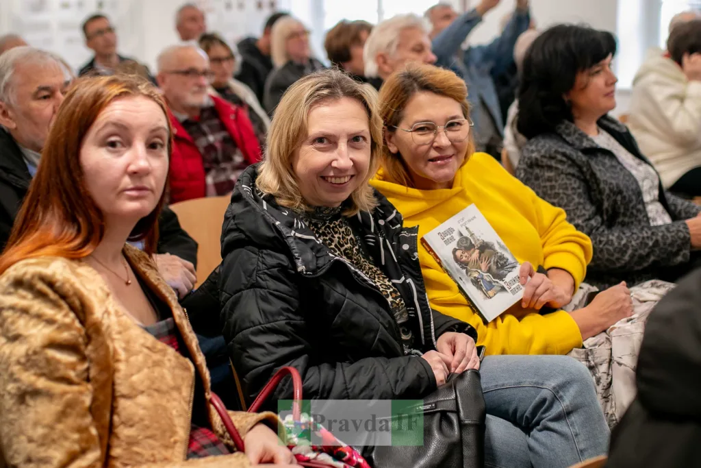Люди на літературному заході з книгою в руках