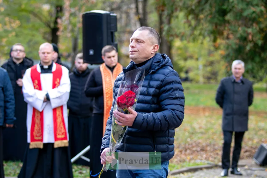 Чоловік з квітами під час церемонії пам’яті