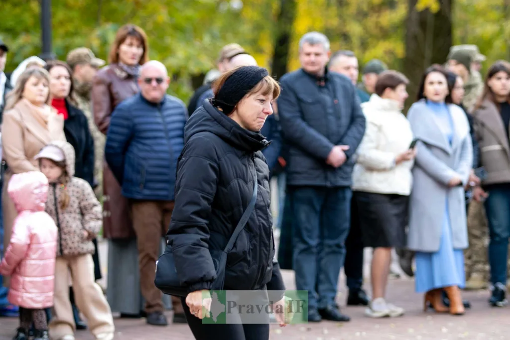 Люди стоять на вулиці під час заходу восени