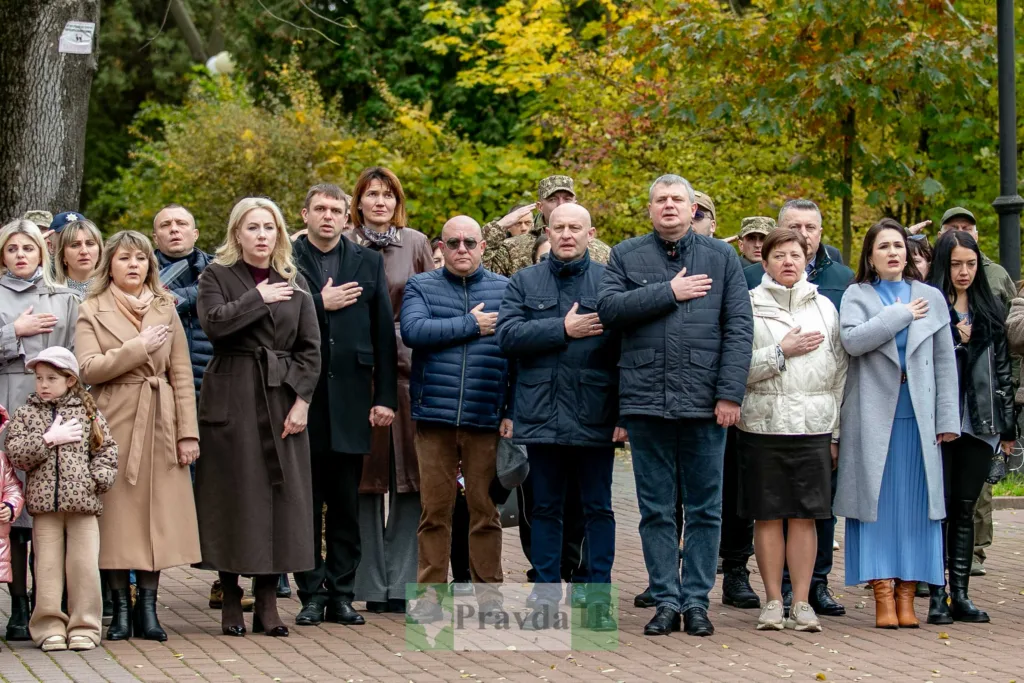 Люди стоять з руками на серці під час церемонії