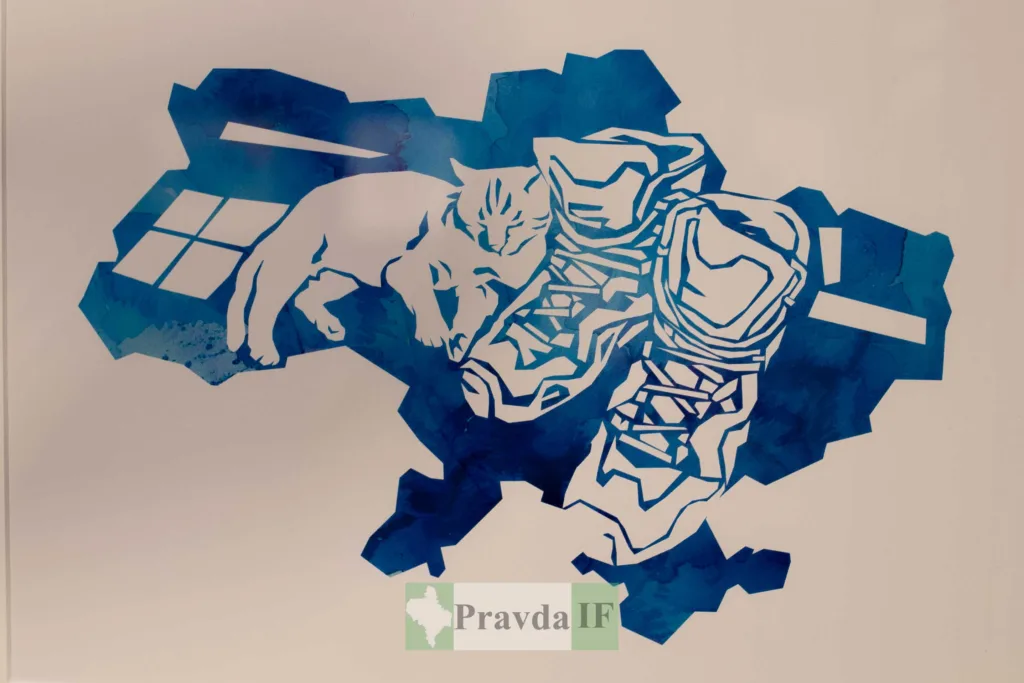 Кіт спить поруч із військовими черевиками на мапі України