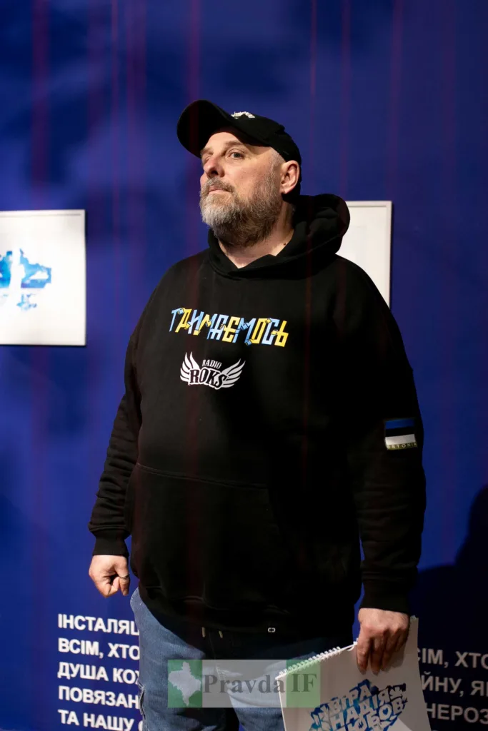 Чоловік у чорній толстовці на виставці